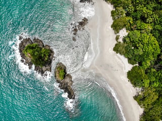 Eine Insel neben Dschungel und Strand in den Wellen