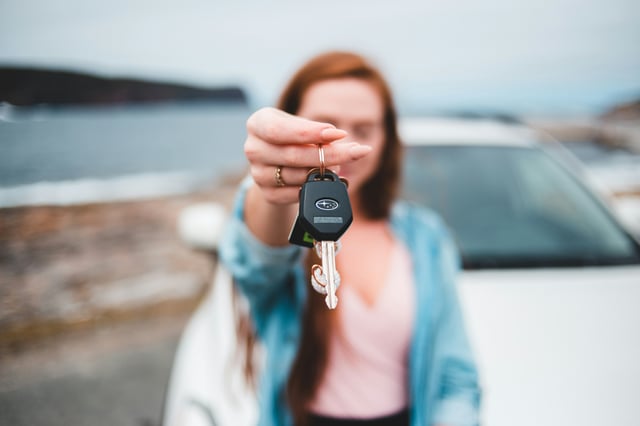 Eine Person übergibt Autoschlüssel