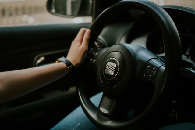 Eine Person hält das Lenkrad eines Autos