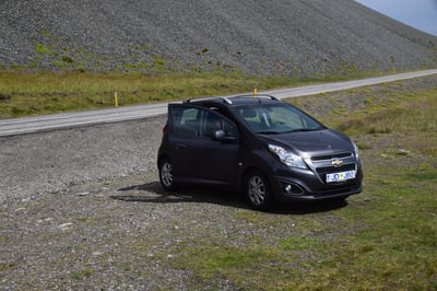 Kleiner Mietwagen neben einer Straße in Island