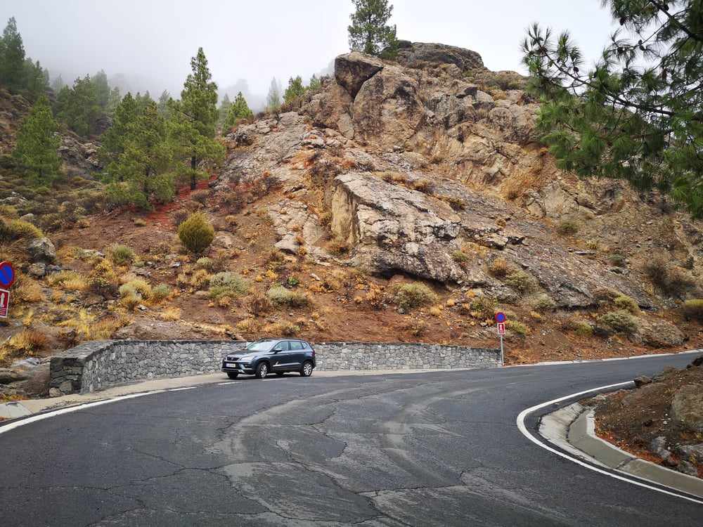 Grauer SUV am Straßenrand in der Nähe von felsigen Bergen in Spanien