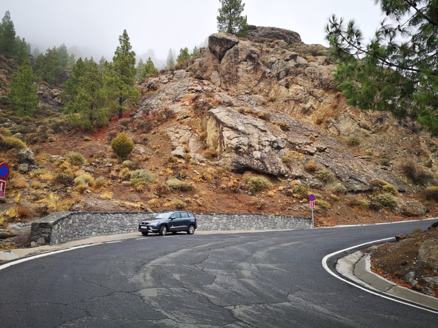Grauer SUV am Straßenrand in der Nähe von felsigen Bergen in Spanien